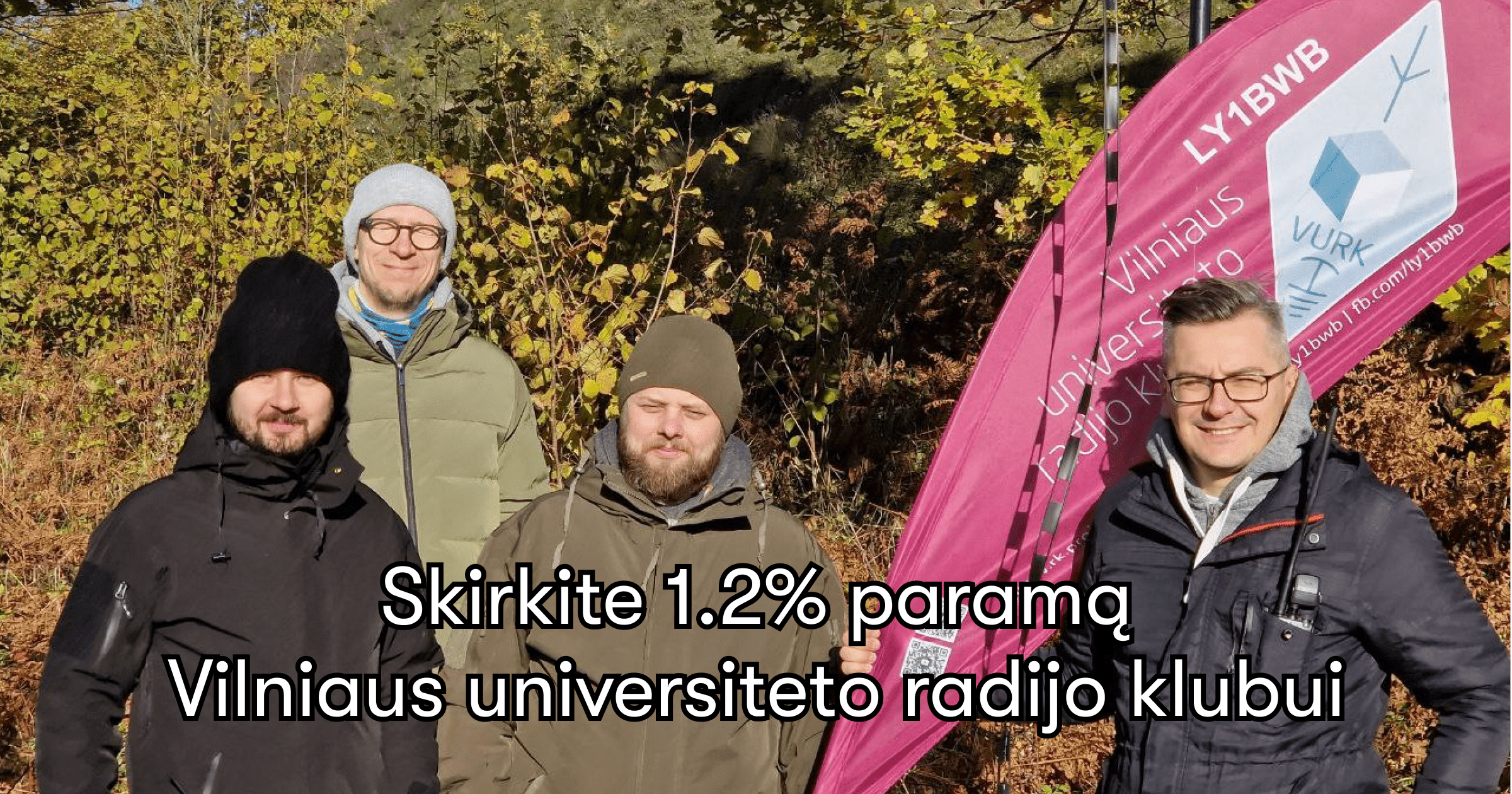 Užrašas "Skirkite 1.2% paramą Vilniaus universiteto radijo klubui. Fone keturi VU radijo klubo nariai stovi prie piliakalnio ir šypsosi. Dešinėje Simonas laiko violetinę klubo vėliavą. Už jų spalvoti rudeniniai medžių lapai.